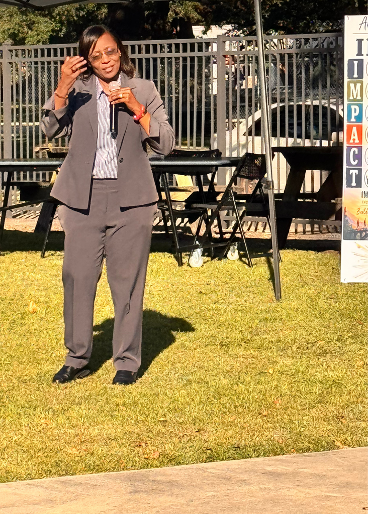 Dr. Bethany A. Giles, GCSD Superintendent, sharing powerful words about the IMPACT literacy has on our students, families, and community with the left side of the IMPACT banner that shows six colored rows display IMPACT acronym.