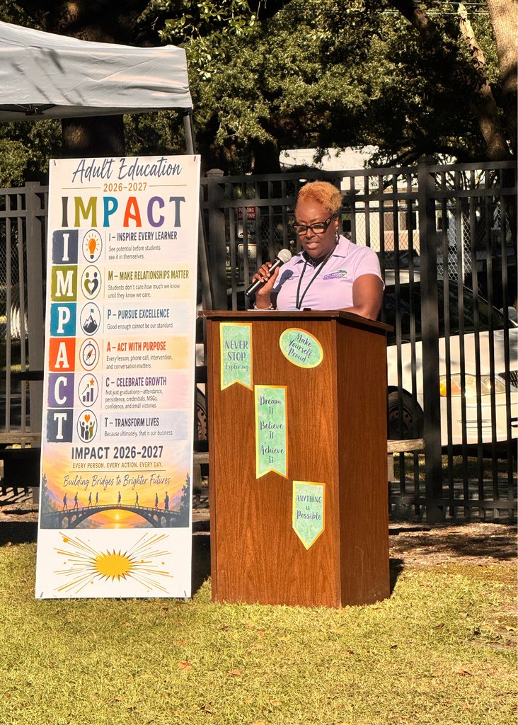 GCAE Director, Dr. Paula Anderson welcoming the attendees at a podium next to the GCAE IMPACT sign which reads: Georgetown County Adult Education IMPACT values poster with tagline "Learn • Grow • Belong • Succeed" and "People • Purpose • Progress." Six colored rows display IMPACT acronym: I - Inspire Every Learner (believe in potential and lifelong learning); M - Make Relationships Matter (build inclusive, supportive connections); P - Pursue Excellence (committed to high-quality programs and continuous improvement); A - Act With Purpose (make intentional decisions creating opportunities); C - Celebrate Growth (recognize progress and honor achievements); T - Transform Lives (open doors and create possibilities for brighter futures). Bottom features photograph of bridge at sunset representing "Building Bridges to Brighter Futures." Includes motto "Every Person. Every Action. Every Day." and signature of Dr. Paula Anderson, Director.