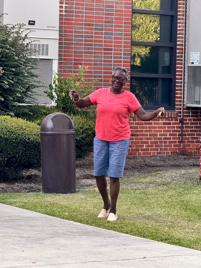 Raffle winner in a red shirt dancing towards her prize.