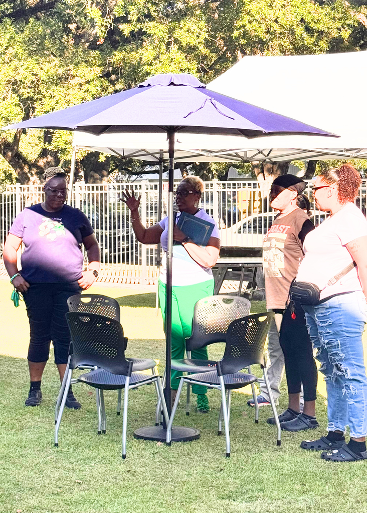 Dr. Anderson and GCAE students standing under a blue umbrella.
