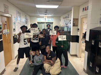 children posing in hallway with signs