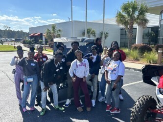 Students posing in front of Honda