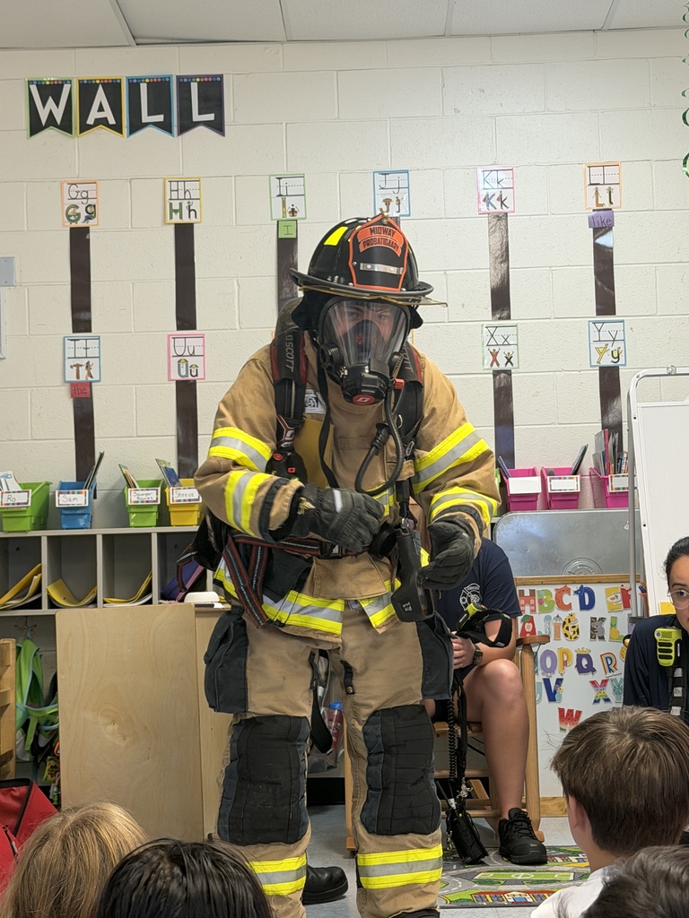 A Midway Fire Rescue firefighter wears full protective gear, including a helmet, breathing mask, and air pack, to help Waccamaw Elementary students learn what a firefighter may look and sound like during an emergency.