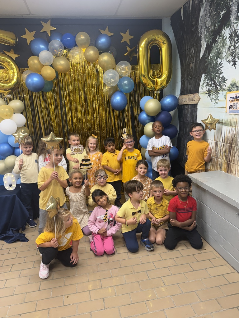 Another large group of students poses together in front of the 50th celebration photo backdrop.
