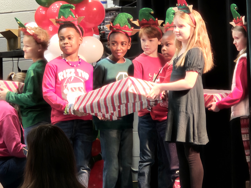 3rd Graders on stage holding large gift box