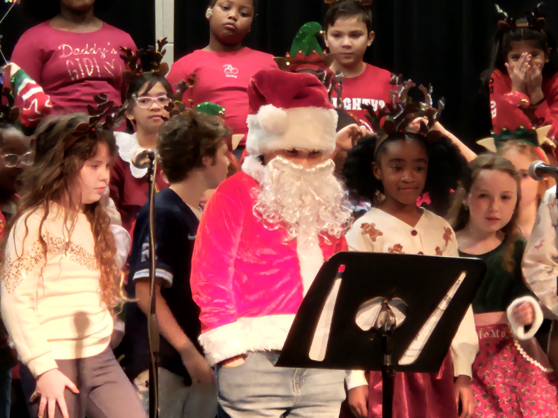 3rd Graders on stage, one student dressed as Santa