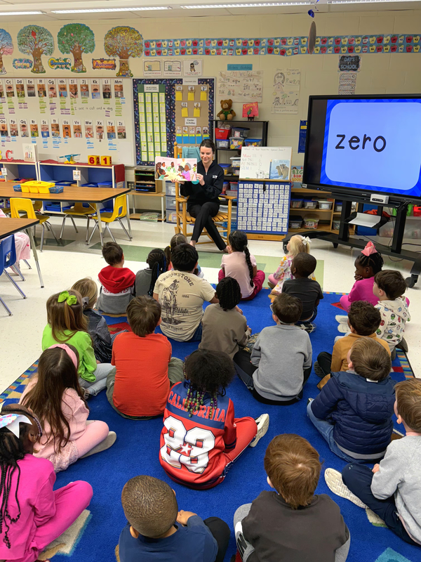 Kindergarten students sitting on the rug listening to a story.
