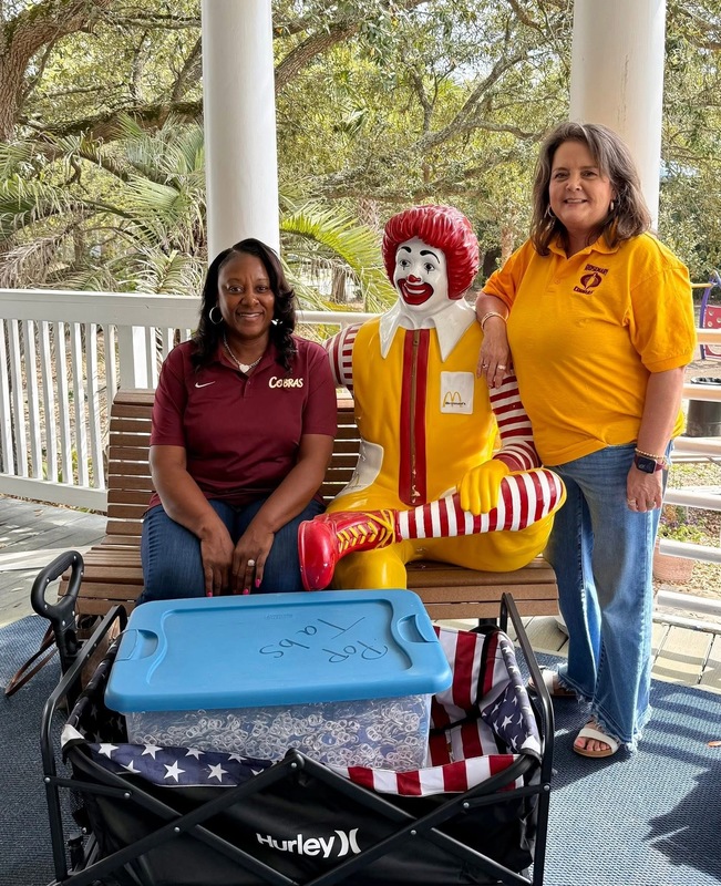 Mrs. Dennison and Mrs. Glisson with the 45 pounds of tabs and Ronald McDonald statue