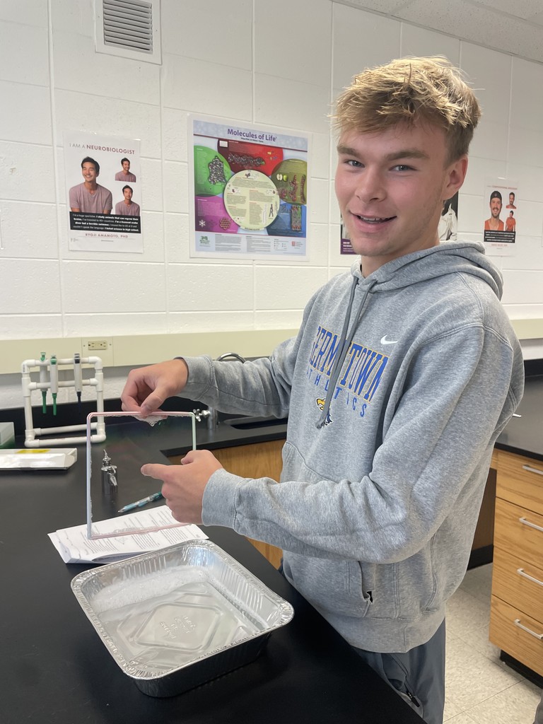 A student pokes at a bubble in AP Biology class learning how they relate to the cell membranes students are learning about in class.