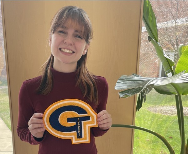 A student holds up an academic letter following the ceremony.