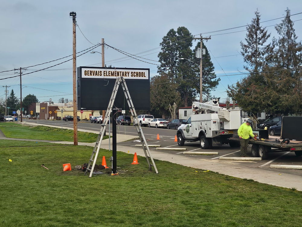 construction workers installing new gervais elementary LED readerboard