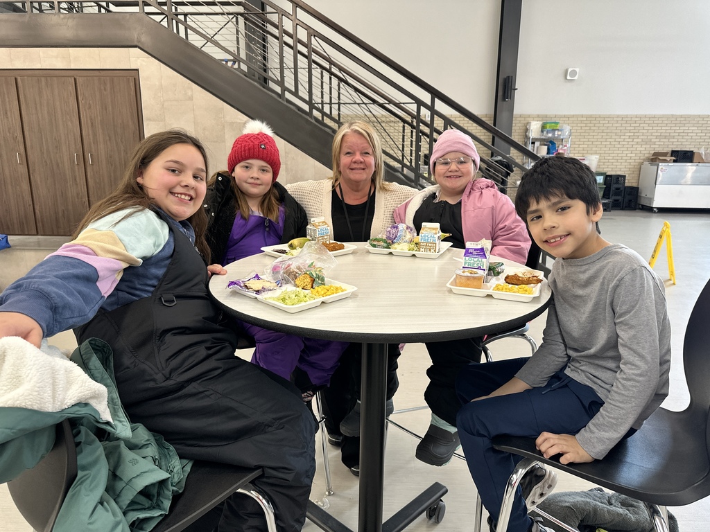 Students and staff member at a table