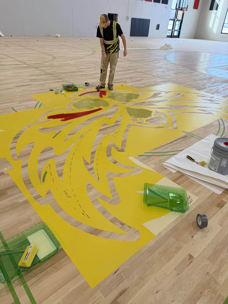 man painting gym floor