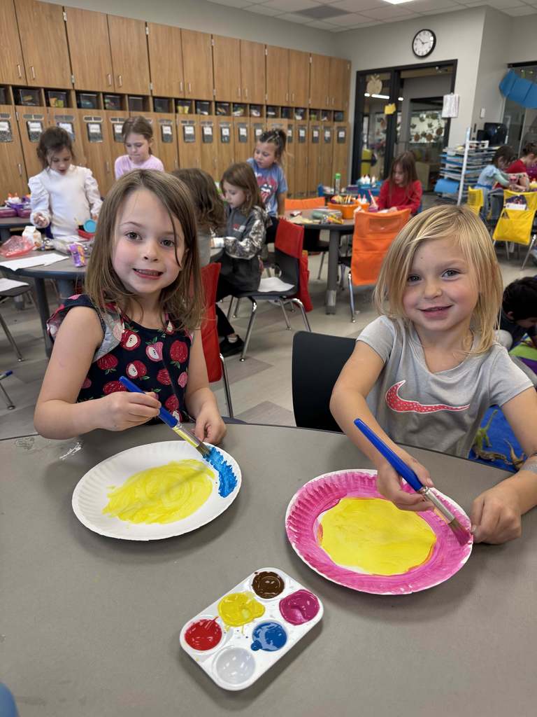 Students smiling and painting 