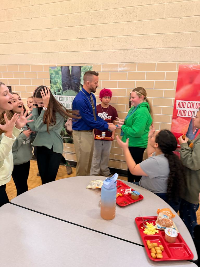 Staff member playing rock paper scissors with students