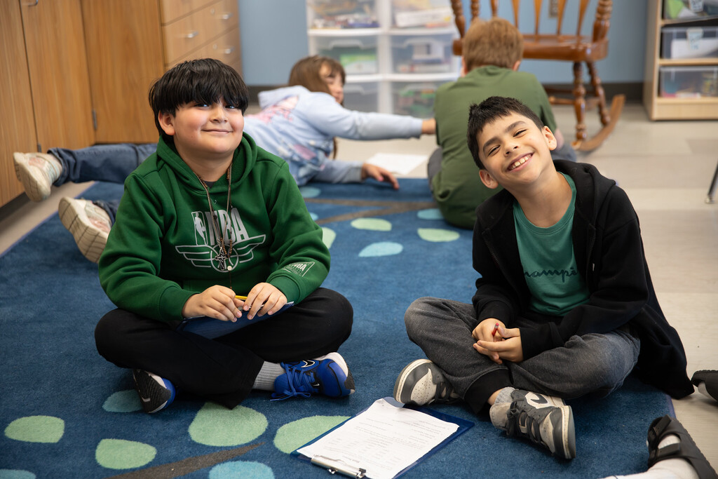 students sitting on the floor and smiling