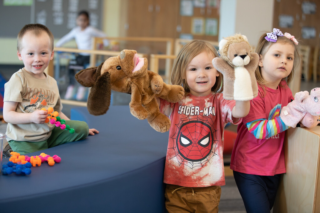Students playing with puppets and toys