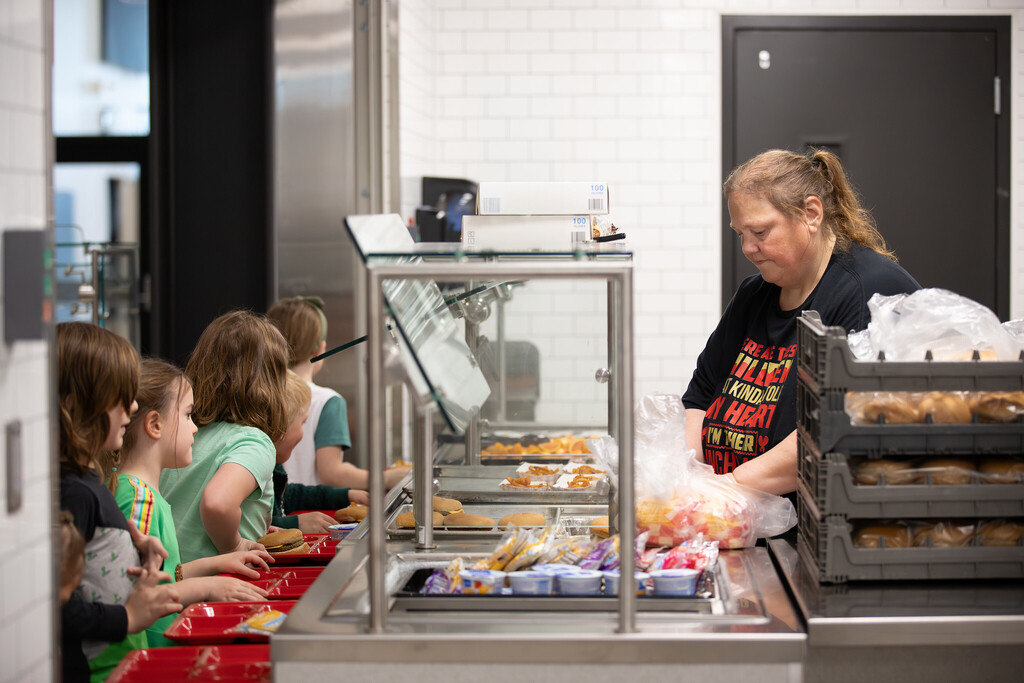 Food service worker handing out lunch