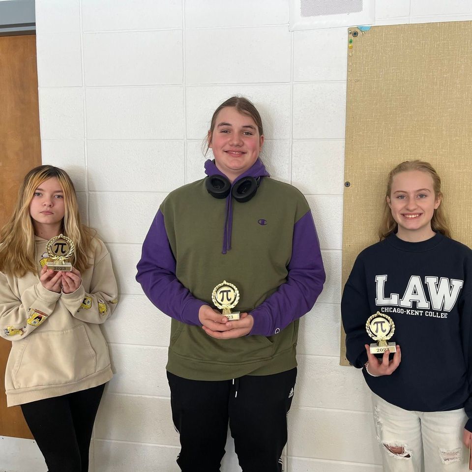 students holding pi trophies