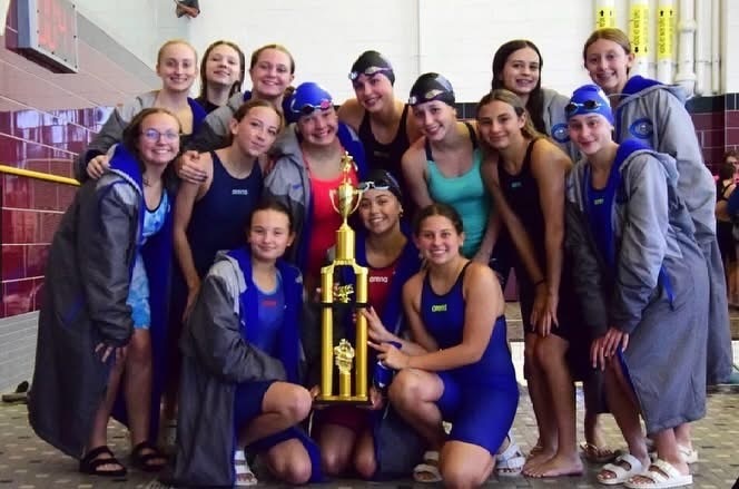 Girls swim team posing with trophy
