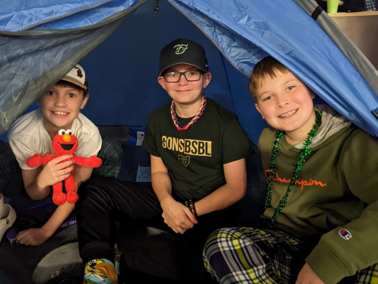 students smiling inside of a tent at camp wanna read