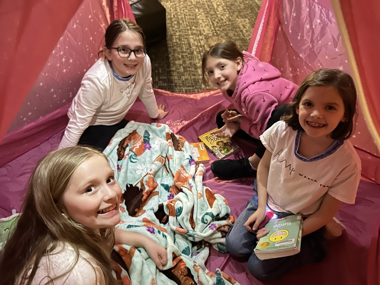 students reading and smiling for a photo at camp wanna read