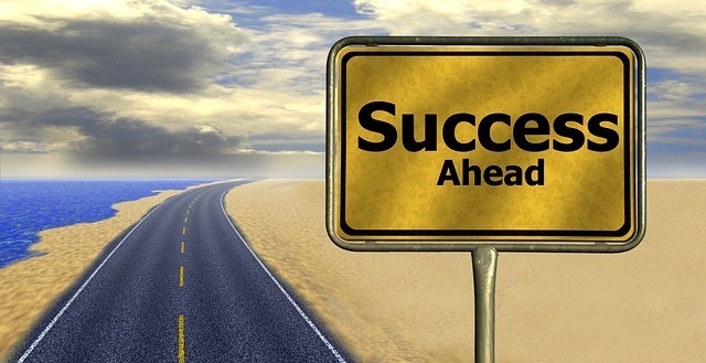 A road with a Success Ahead sign indicating success is in the future