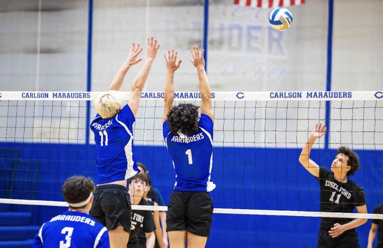 CHS Boys Club Volleyball team, two players blocking at the net