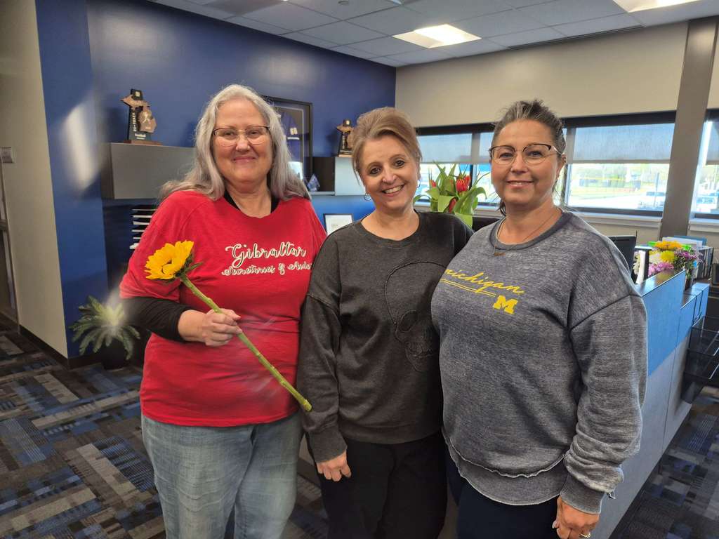 Three female staff members smiling in an office