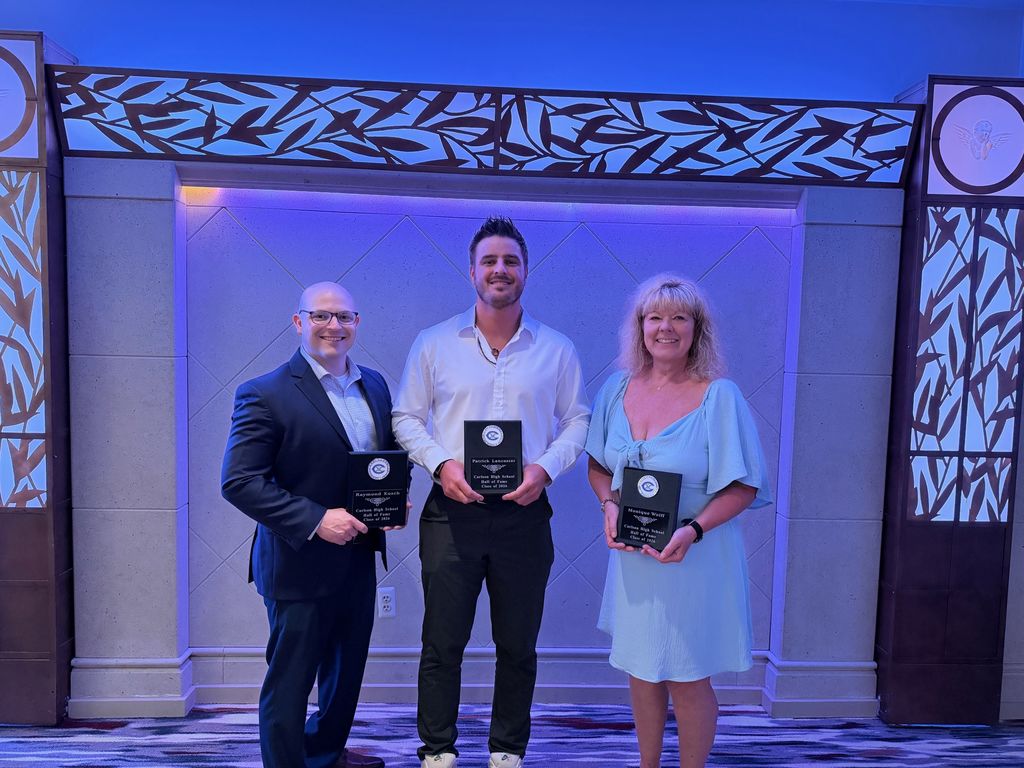 Three individuals holding plaques