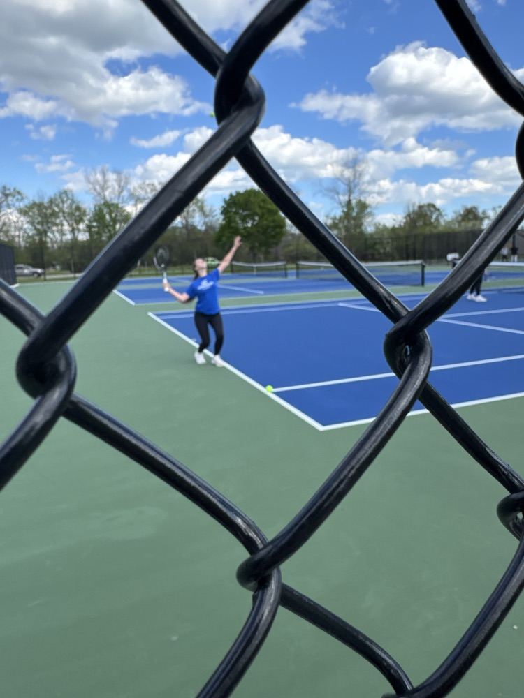 Picture of a girl serving a tennis ball