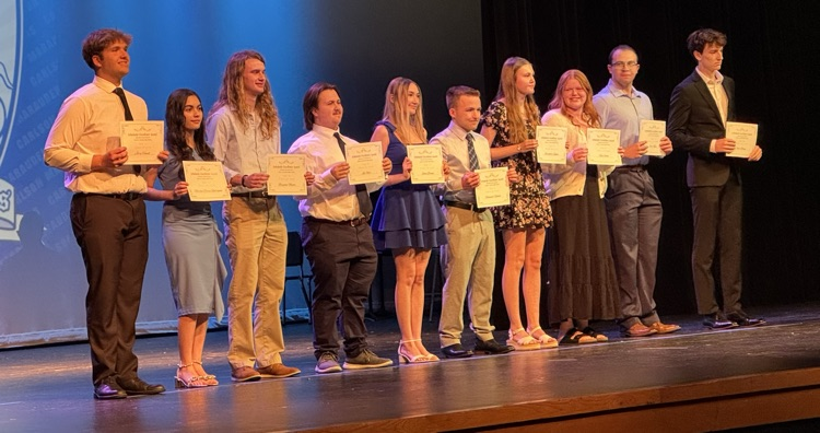 students receiving scholarships on a stage