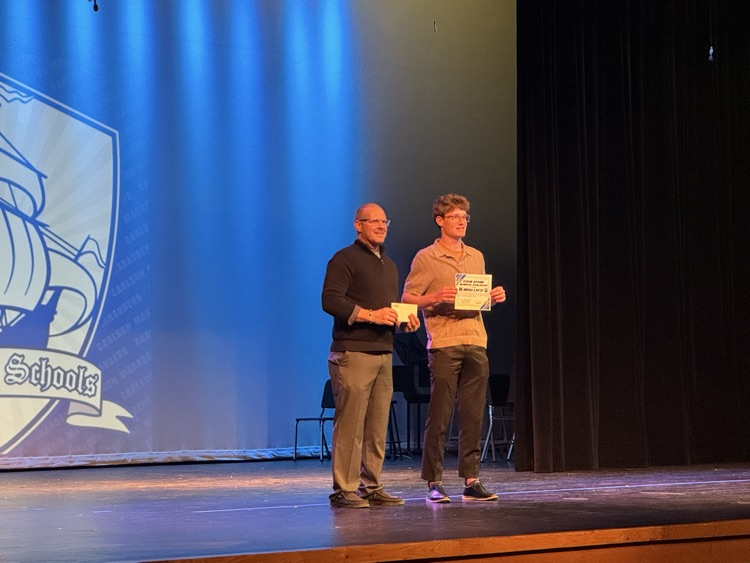 students receiving scholarships on a stage