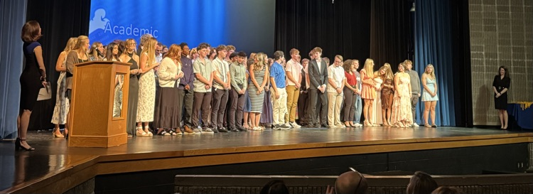 students receiving scholarships on a stage