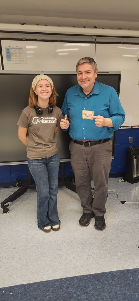 Student standing next to a teacher and the teacher is giving a thumbs up