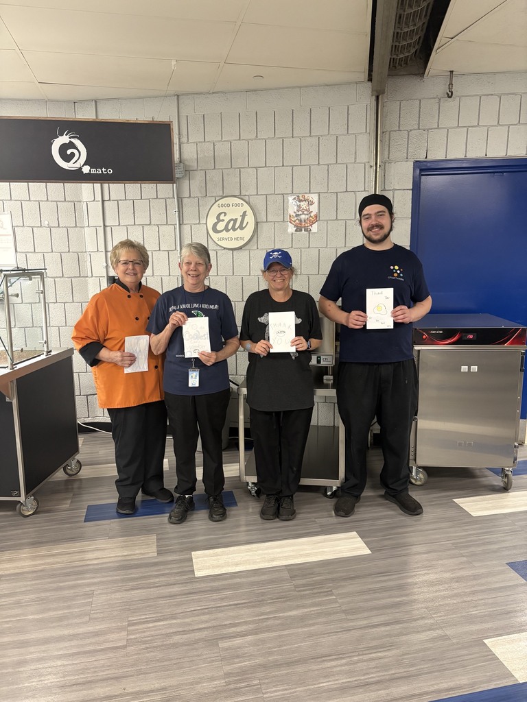 Four food service employees holding cards