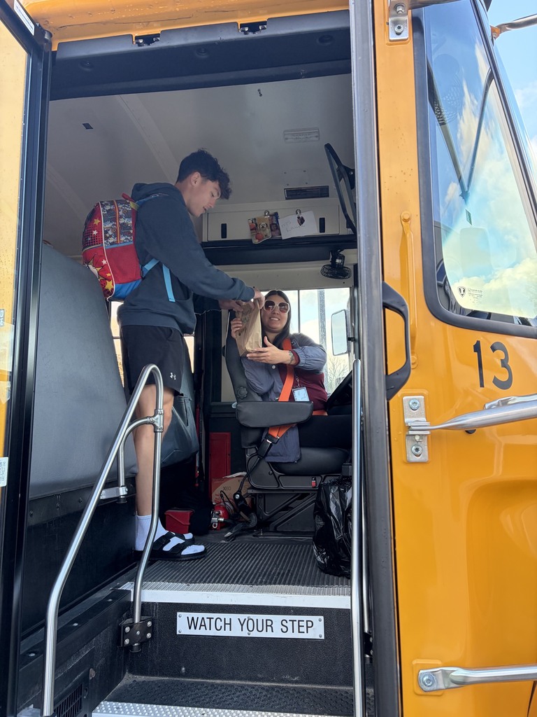 Student presenting a bus driver a giftbag