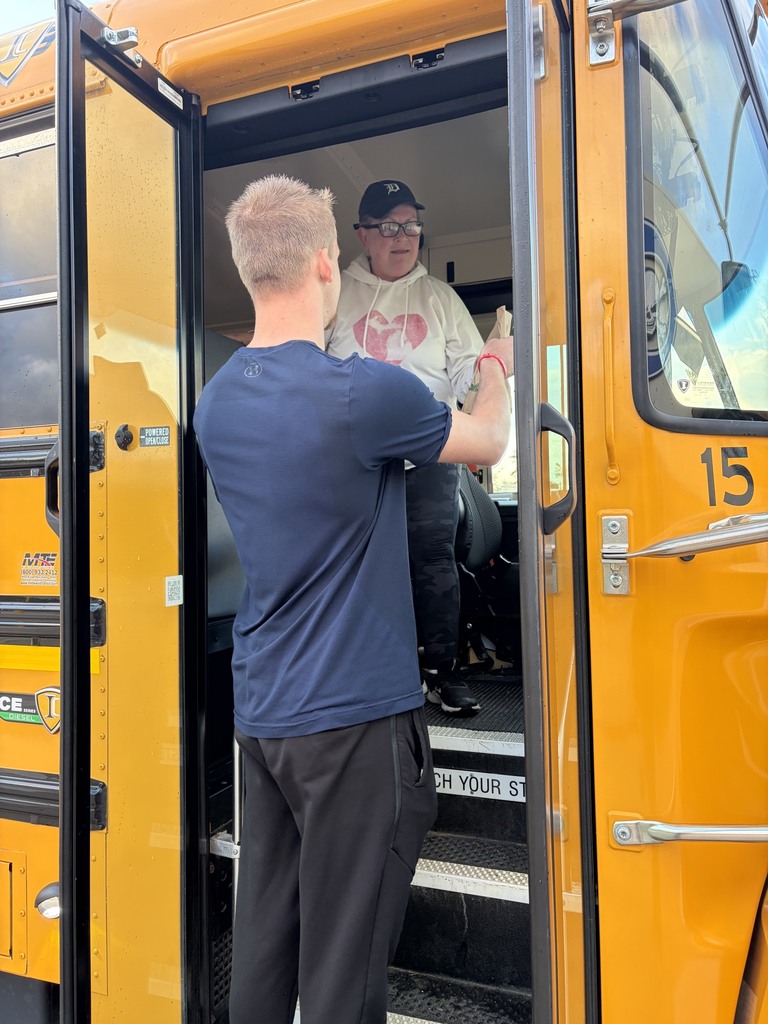 Student presenting a bus driver a giftbag