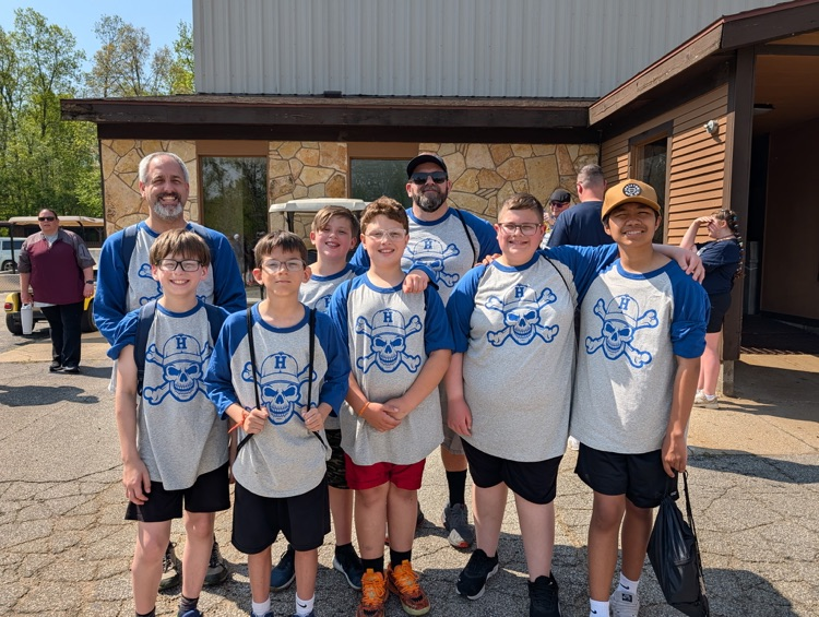 a group of fifth grade students and chaperones smiling for a picture at camp after just arriving 