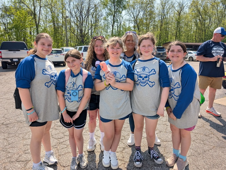 a group of fifth grade students and chaperones smiling for a picture at camp after just arriving 