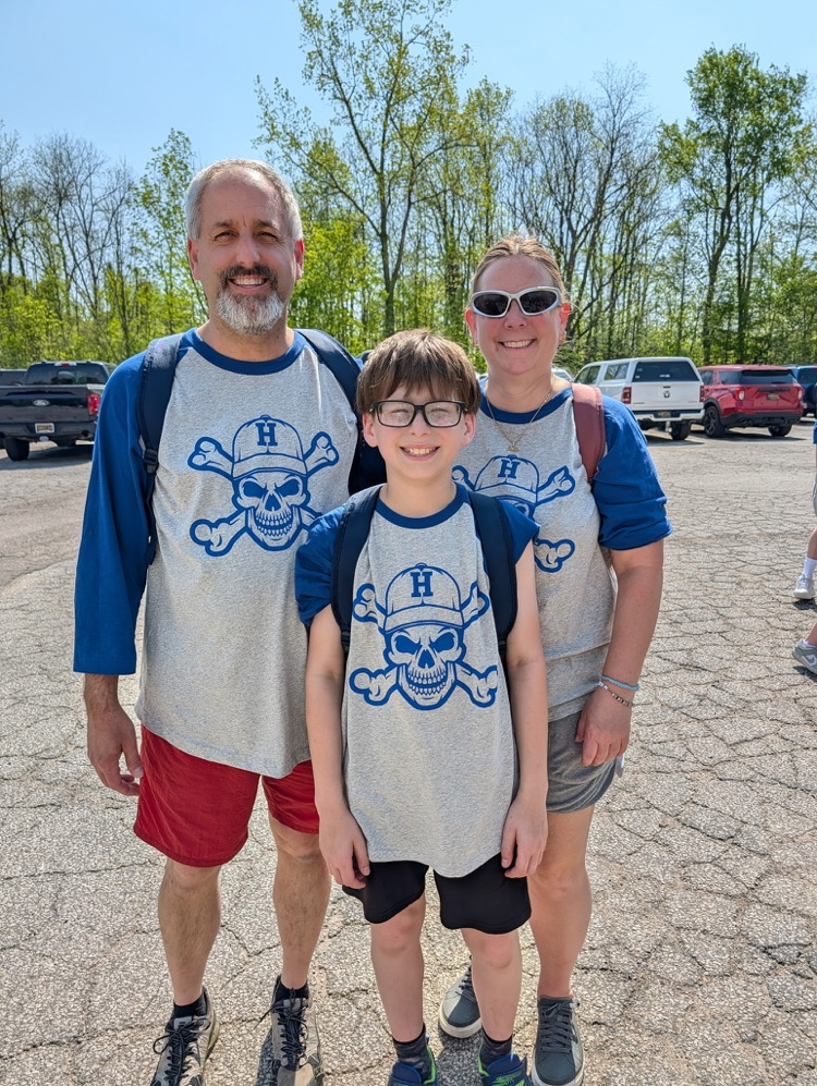 a fifth grade student and chaperones smiling for a picture at camp after just arriving 