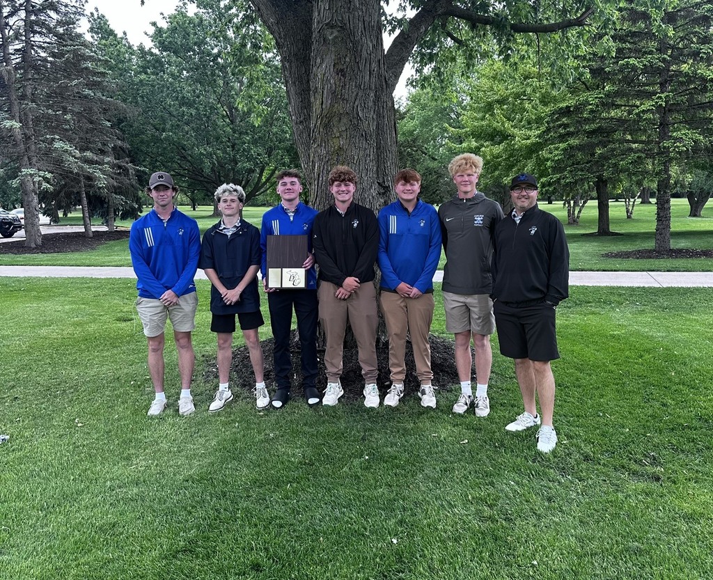 Golf team and coach with trophy on  golf course