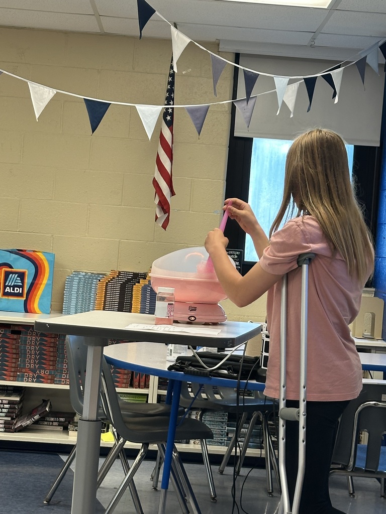 A student is standing up with crutches and showing how to make cotton candy