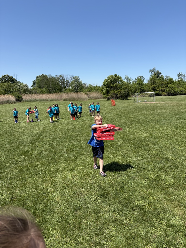 Boy carrying pizza boxes for a field day event.