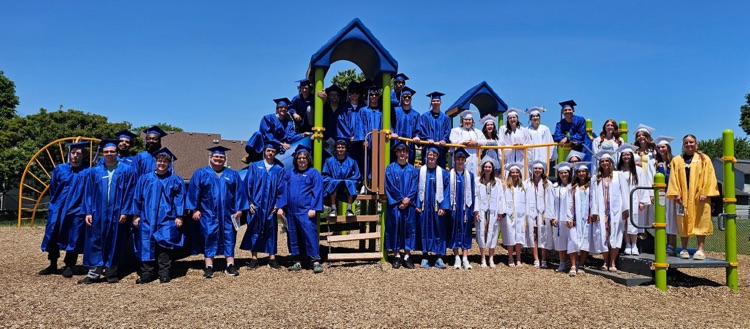 class of 2026 graduates in their cap and gown on the Hunter Elementary playground for senior walk through