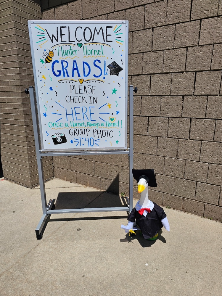 white board sign reading welcome hunter grads please check in here once a hornet always a hornet and a decorative goose dressed in a cap and gown