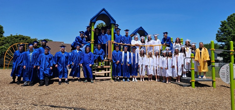 class of 2026 graduates in their cap and gown on the Hunter Elementary playground for senior walk through