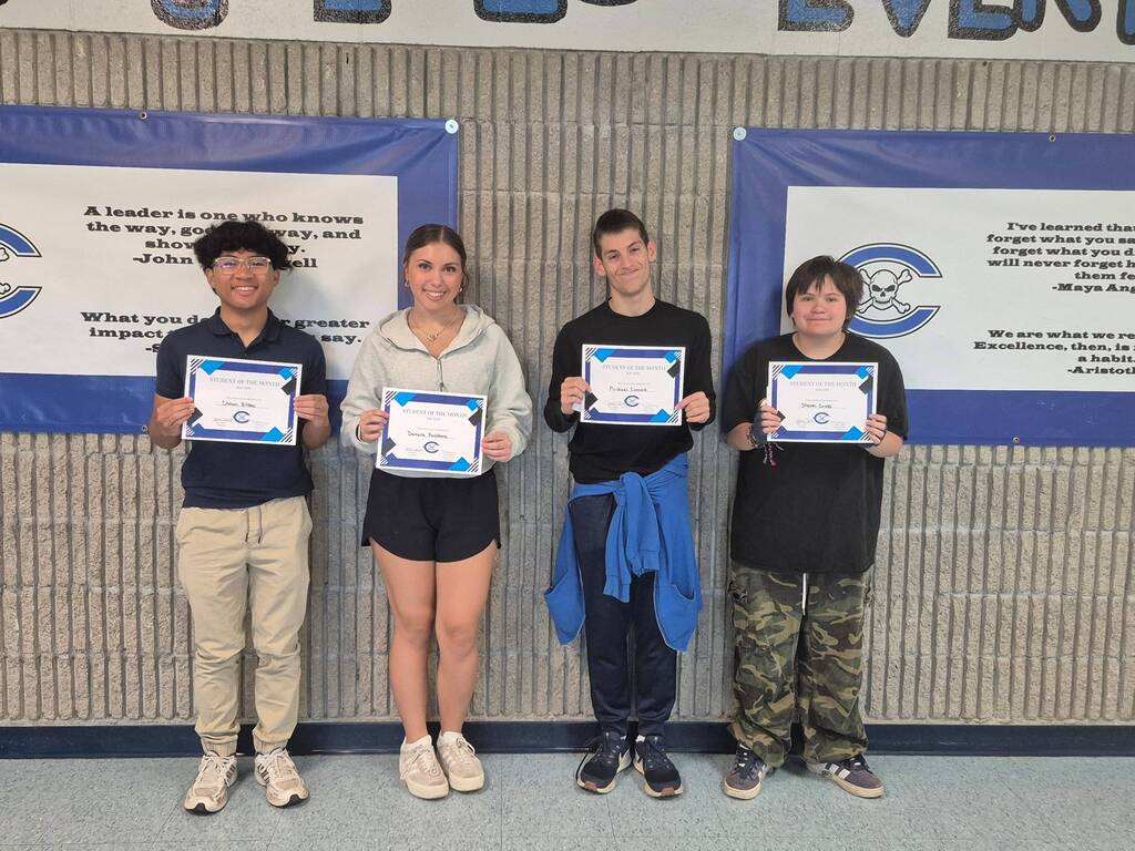 Four students holding award certificates