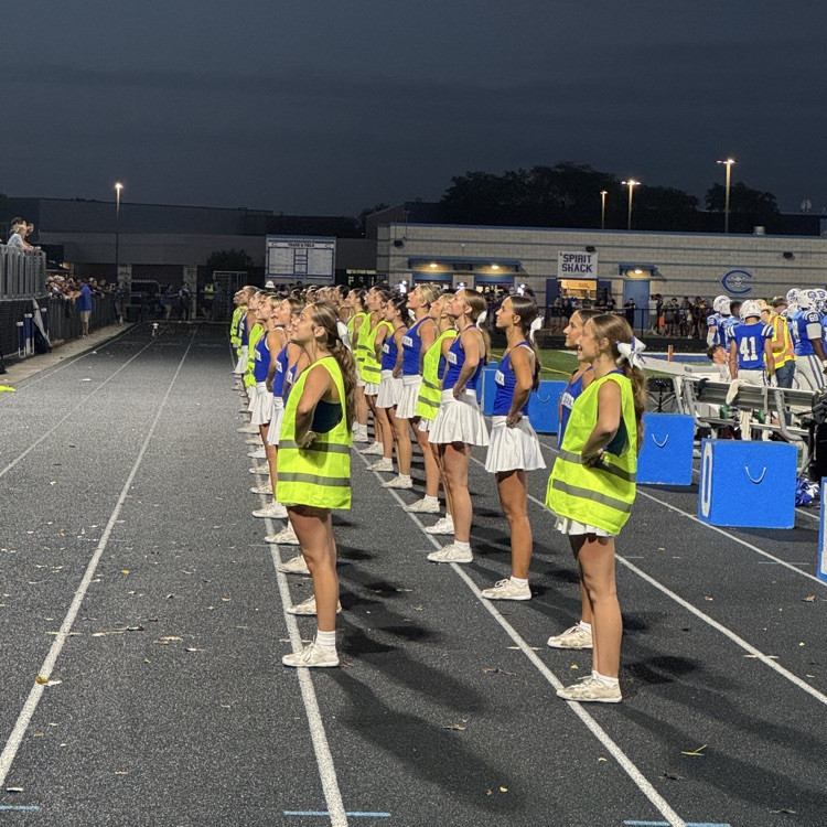 cheer team standing on the track facing the stands