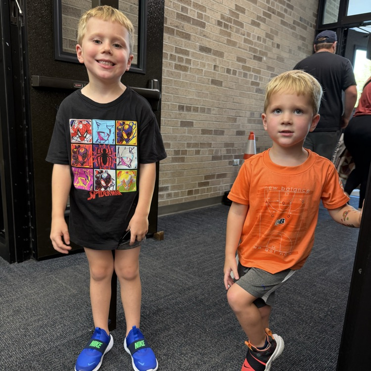 two students smiling in school doorway 